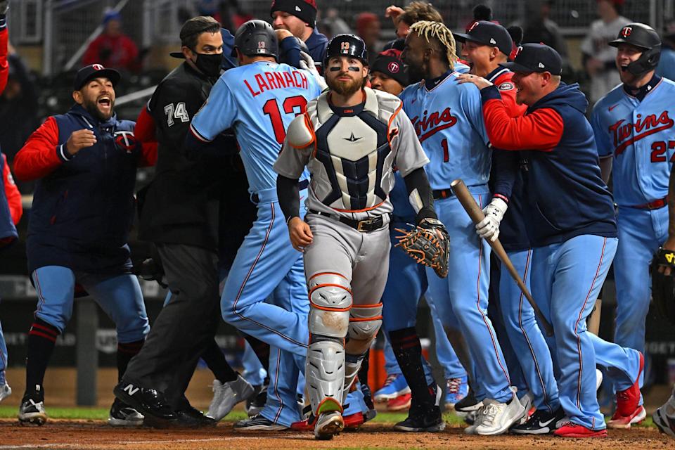 Detroit Tigers catcher Eric Haase walks off the field as the Minnesota Twins celebrate their walk-off win.