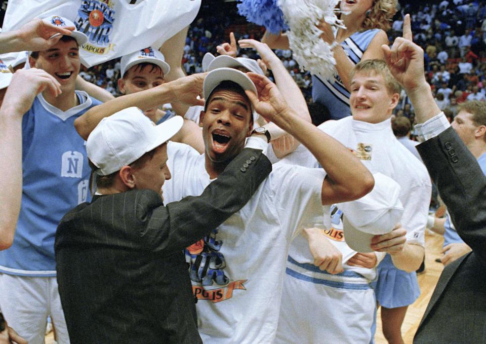 UNC’s Hubert Davis celebrates on the court with teammates after the Tar Heels defeated Temple 75-72 in NCAA East regional championship game on March 24, 1991. (AP Photo/Bill Kostroun)