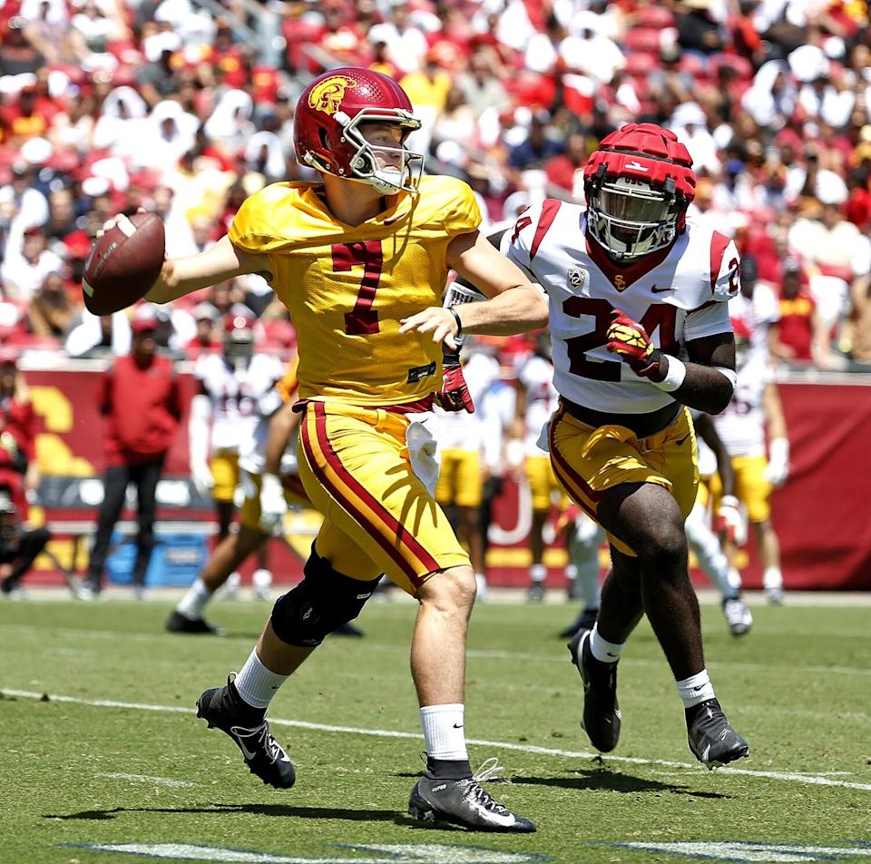 USC quarterback Miller Moss attempts a pass under pressure from Julien Simon