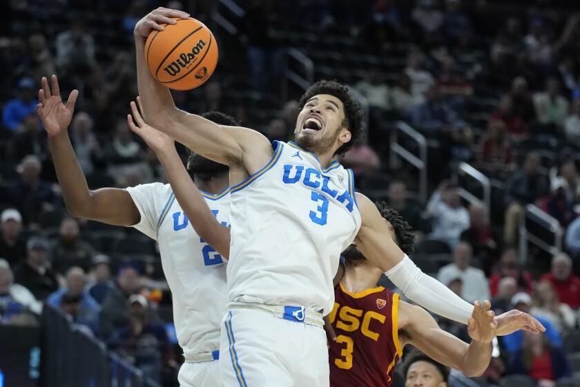 UCLA's Johnny Juzang (3) grabs a rebound Southern California's Isaiah Mobley, right, during the second half of an NCAA college basketball game in the semifinal round of the Pac-12 tournament Friday, March 11, 2022, in Las Vegas. (AP Photo/John Locher)