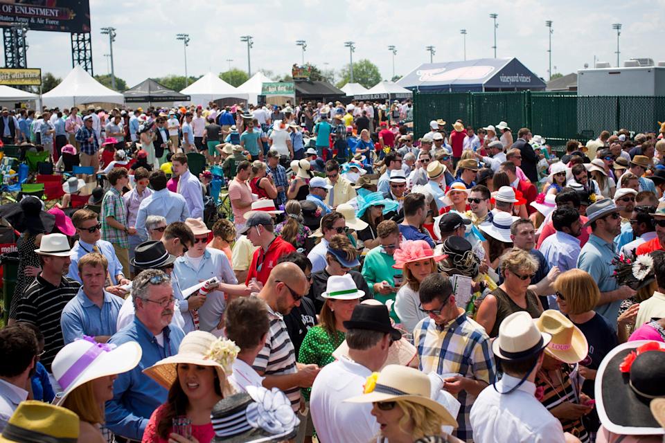 A large crowd lined up in front of one of the infield betting stands at Churchill Downs.