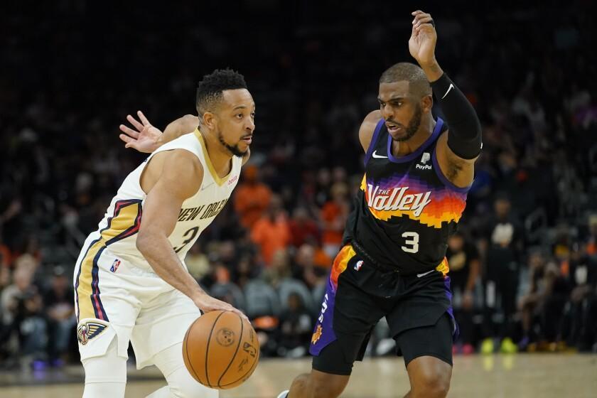 New Orleans Pelicans guard CJ McCollum, left, drives as Phoenix Suns guard Chris Paul defends during the second half of Game 5 of an NBA basketball first-round playoff series, Tuesday, April 26, 2022, in Phoenix. (AP Photo/Matt York)