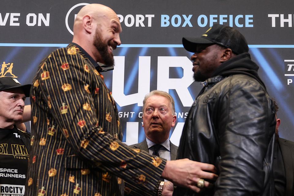 World Boxing Council (WBC) heavyweight title holder Britain's Tyson Fury (L) tickles his compatriot Dillian Whyte as they meet during a pre-fight press conference at Wembley Stadium in west London, on April 20, 2022. - Tyson Fury is set to have his first bout on home soil in nearly four years when he defends his World Boxing Council (WBC) heavyweight title in an all-British clash against Dillian Whyte at Wembley Stadium on April 23. (Photo by Adrian DENNIS / AFP) (Photo by ADRIAN DENNIS/AFP via Getty Images)