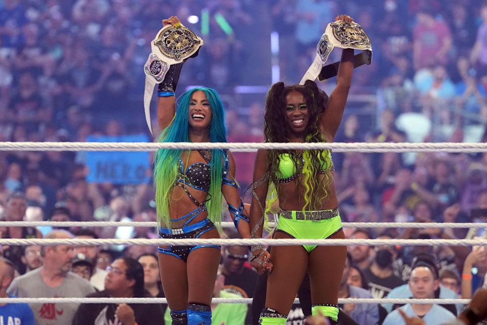 Sasha Banks (left) and Naomi celebrate after winning the women’s Tag Team Championship match.