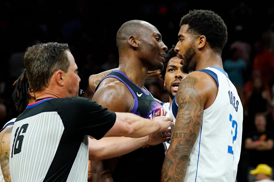 Referee David Guthrie (16) tries to separate Phoenix Suns center Bismack Biyombo, middle, and Dallas Mavericks forward Marquese Chriss, right, as Mavericks forward Sterling Brown, second from right, argues during the second half of Game 5 of an NBA basketball second-round playoff series Tuesday, May 10, 2022, in Phoenix. The Suns won 110-80.