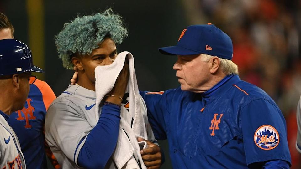 Apr 8, 2022; Washington, District of Columbia, USA; New York Mets shortstop Francisco Lindor (12) covers his face after being hit by pitch while manager Buck Showalter (11) walks with him during the fifth inning against the Washington Nationals at Nationals Park. Mandatory Credit: Tommy Gilligan-USA TODAY Sports