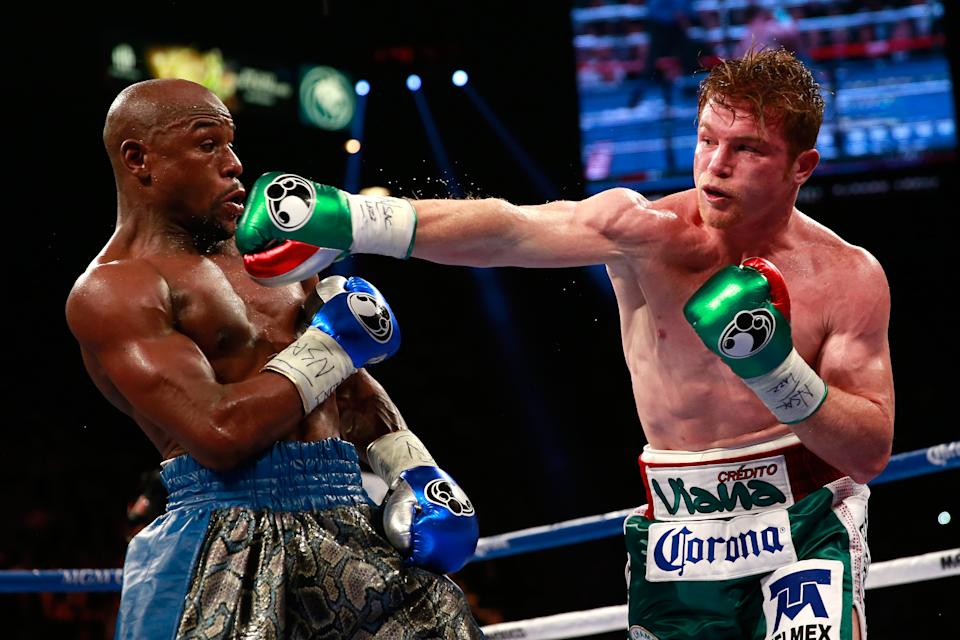 LAS VEGAS, NV - SEPTEMBER 14: (R-L) Canelo Alvarez throws a right at Floyd Mayweather Jr. during their WBC/WBA 154-pound title fight at the MGM Grand Garden Arena on September 14, 2013 in Las Vegas, Nevada. (Photo by Chris Trotman/Golden Boy/Golden Boy via Getty Images)