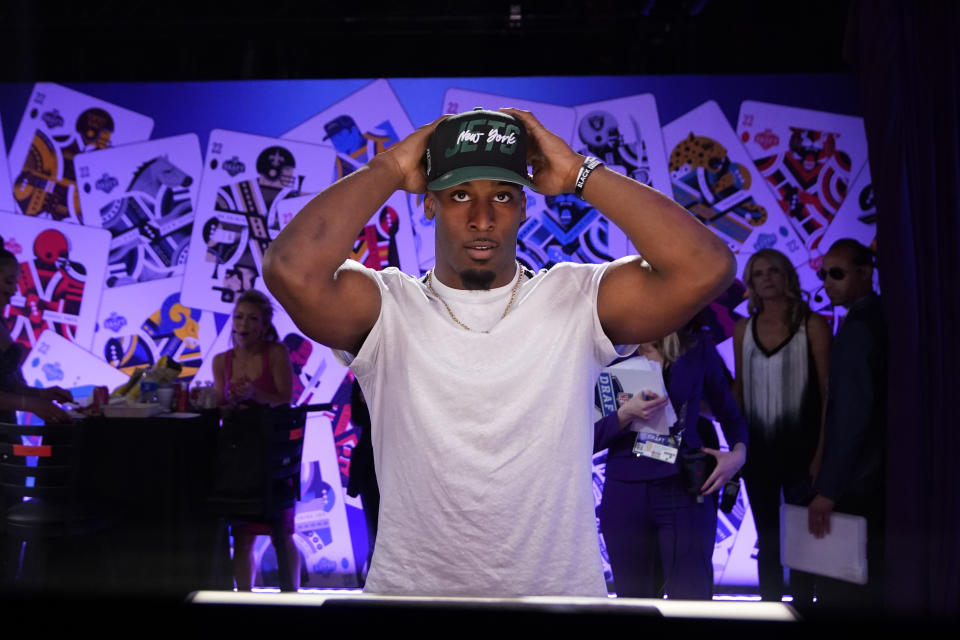 Iowa state running back Breece Hall puts on a hat after being selected by the New York Jets during the second round of the NFL football draft Friday, April 29, 2022, in Las Vegas. (AP Photo/John Locher)