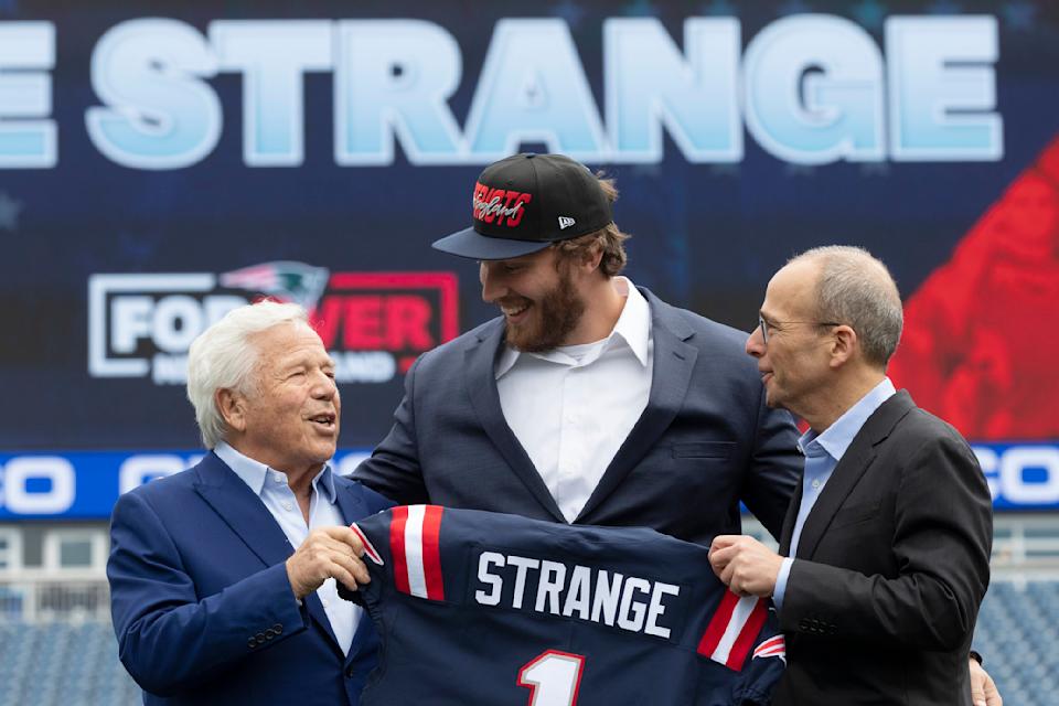 New England Patriots owner Robert Kraft, left, and Patriots president Jonathan Kraft, right, pose with first-round pick Cole Strange. (AP Photo/Michael Dwyer)