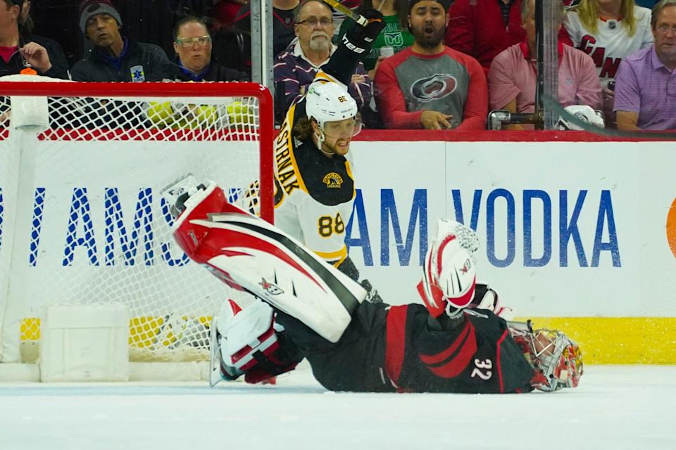 Boston Bruins right wing David Pastrnak runs into Carolina Hurricanes goaltender Antti Raanta.