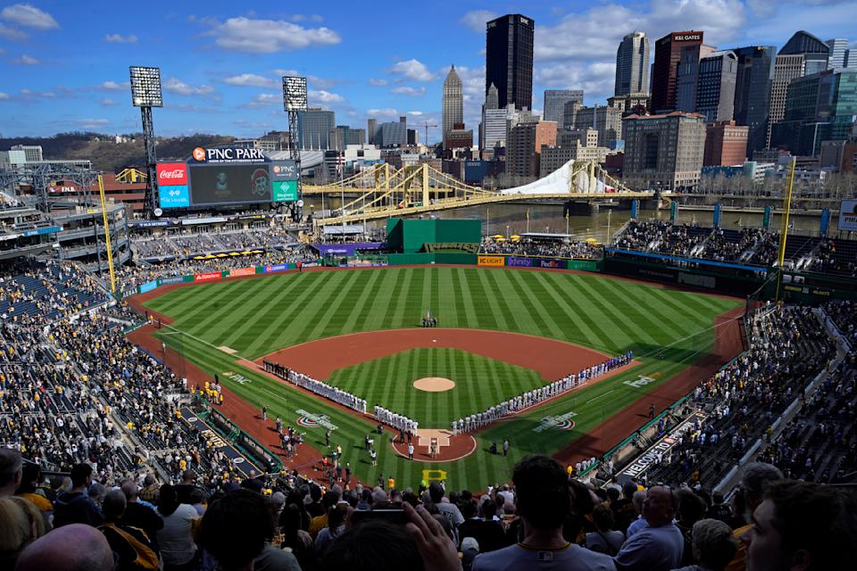 The Pittsburgh Pirates and the Chicago Cubs stand for the national anthem before the Pirates' home opener on April 12. (AP/Gene J. Puskar)