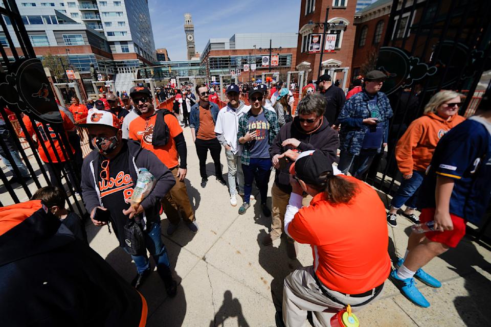 Spectators walk through the gates prior to a baseball game between the Baltimore Orioles and the Milwaukee Brewers on April 11. (AP Photo/Julio Cortez)