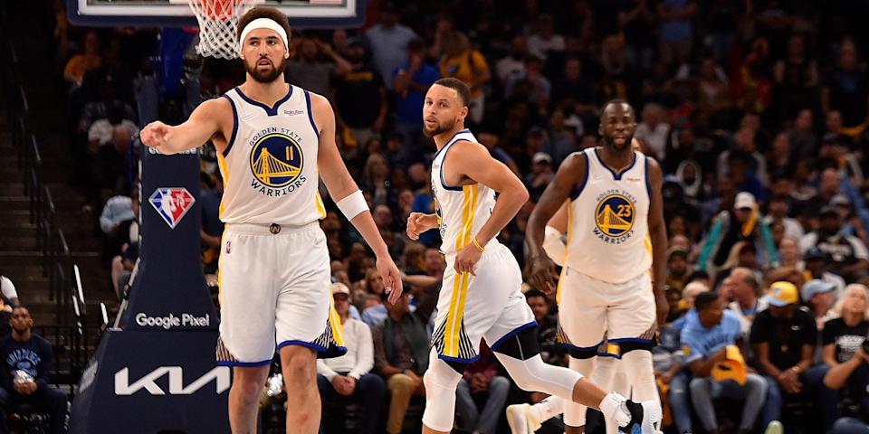 Klay Thompson, Stephen Curry, and Draymond Green run down the court during a game.