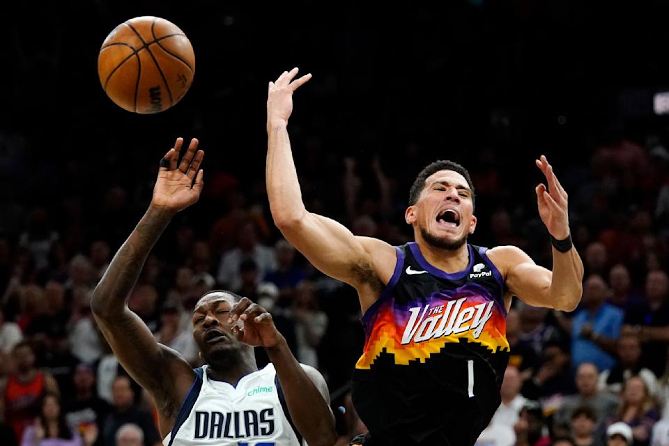 Phoenix Suns guard Devin Booker, right, gets fouled by Dallas Mavericks forward Dorian Finney-Smith, left, as Booker goes up for a shot during Game 5 of their second-round playoff series on May 10, 2022, in Phoenix. Finney-Smith was assessed a flagrant 1 foul. (AP Photo/Ross D. Franklin)