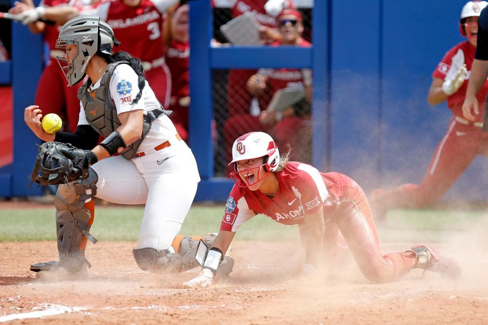 OU's Jayda Coleman (24) celebrates after scoring at home as Texas' Mary Iakopo (33) tries to hold on to the ball in the in the fifth inning.