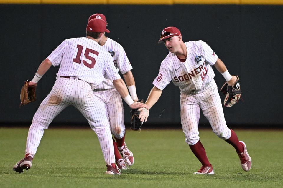 Jun 19, 2022; Omaha, NE, USA; Oklahoma Sooners center fielder Tanner Tredaway (10) celebrates with second baseman Jackson Nicklaus (15) after making a diving catch in the eighth inning against the Notre Dame Fighting Irish at Charles Schwab Field. Mandatory Credit: Steven Branscombe-USA TODAY Sports