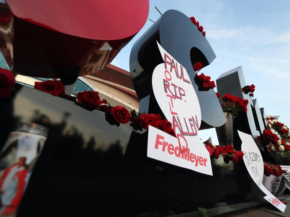 Sign outside Portland Trail Blazers arena decorated with 'RIP Paul Allen' signs