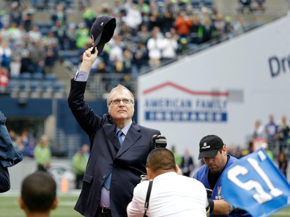 Seattle Seahawks owner Paul Allen waves his hat on field at game