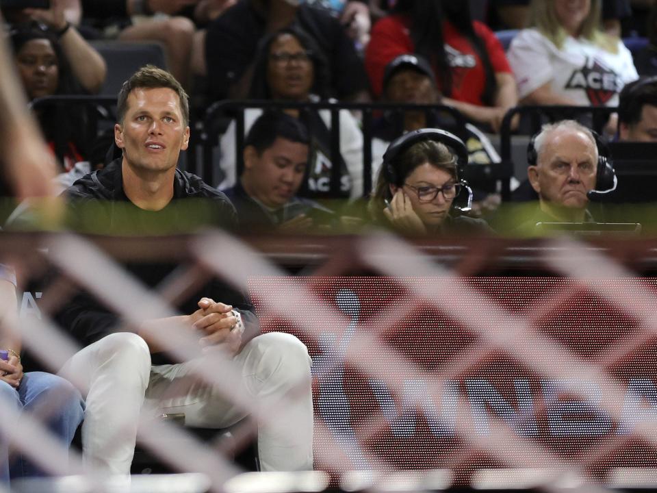 Tom Brady sits courtside at a WNBA game.