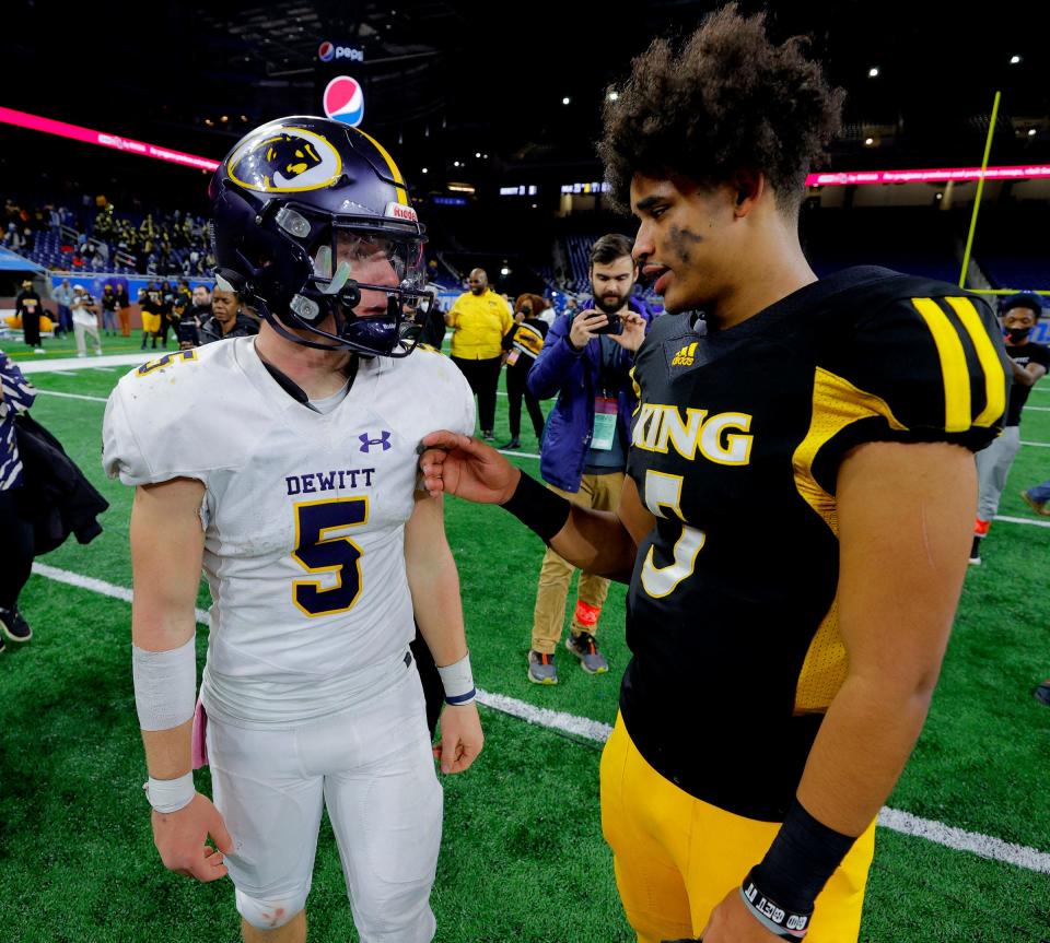 DeWitt quarterback Tyler Holtz, left, and Detroit King quarterback Dante Moore talk and hug it out after King won the Michigan High School Athletic Association Division 3 final against DeWitt, 25-21, at Ford Field in Detroit on Saturday, Nov, 27, 2021.