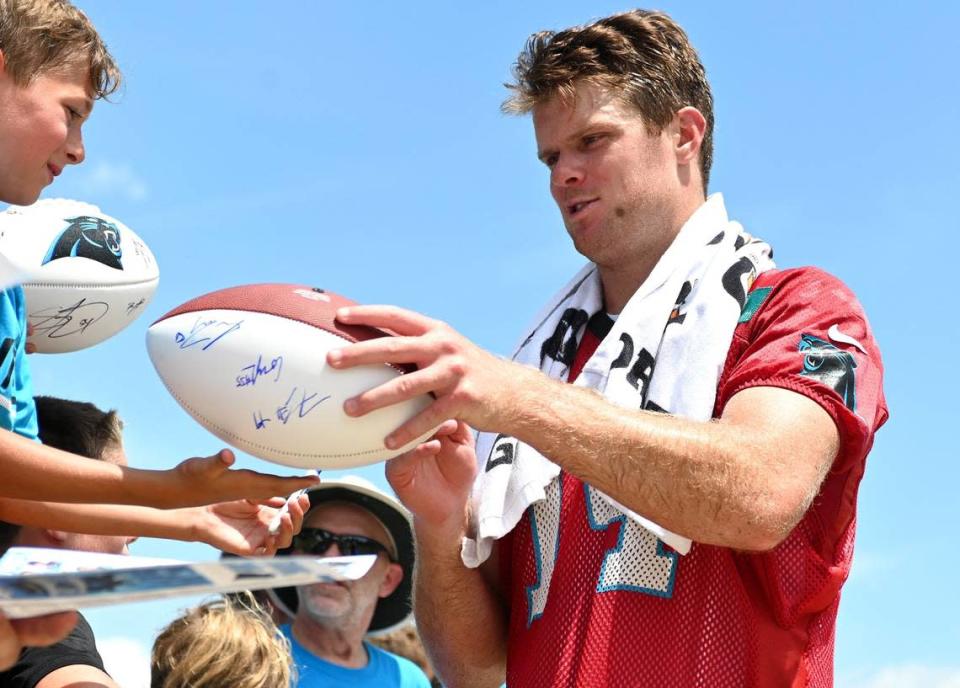 Carolina Panthers quarterback Sam Darnold, right, stops to sign an autograph for a fan following practice on Wednesday, July 27, 2022 at Wofford College in Spartanburg, SC.