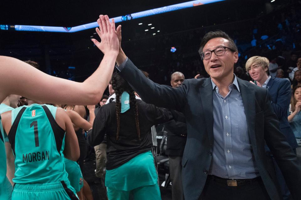 Team owner Joe Tsai high fives New York Liberty players.