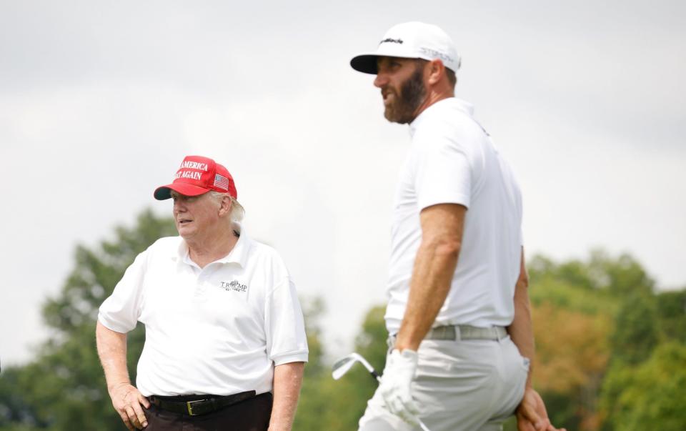 President Donald Trump looks on as Dustin Johnson of 4 Aces GC plays his shot - GETTY IMAGES