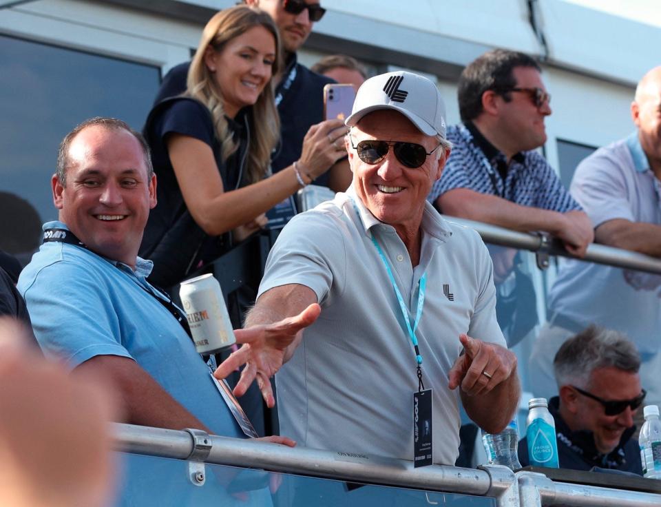 Greg Norman, CEO of LIV Golf, tosses beers to spectators at the 18th green during the Portland Invitational LIV Golf tournament in North Plains, Ore., Saturday, July 2, 2022. (AP Photo/Steve Dipaola)