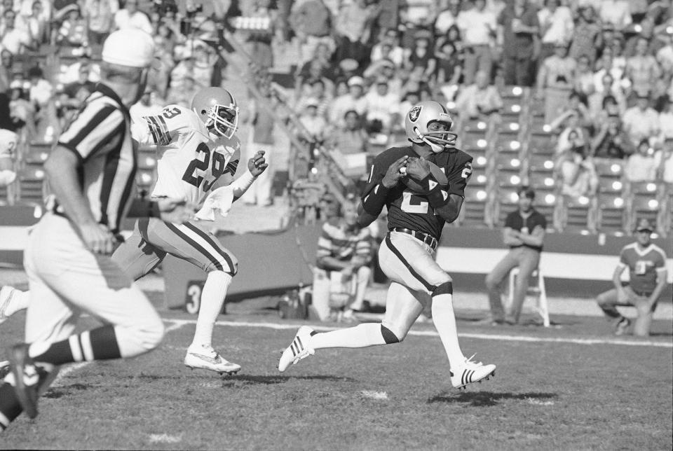 Raiders wide receiver Cliff Branch, right, catches a pass from quarterback Jim Plunkett for a 64-yard gain during the first quarter of a playoff win over the Cleveland Browns in Los Angeles, Jan. 8, 1983. (AP Photo, File)
