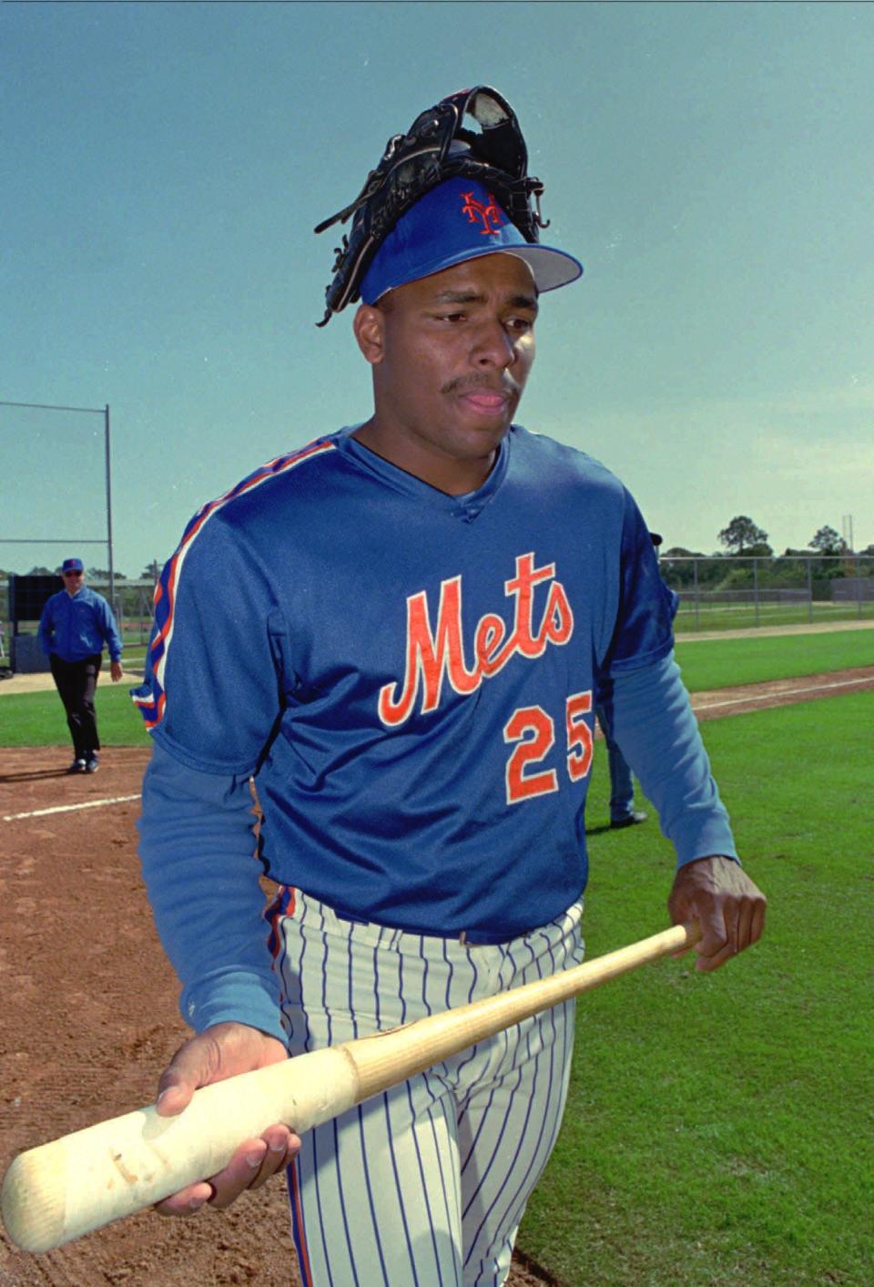 New York Mets outfielder Bobby Bonilla wears a glove on his cap as he leaves the practice field on Feb. 25, 1993.
