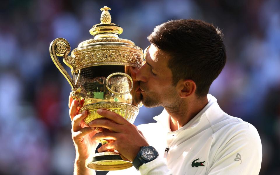 Novak Djokovic of Serbia kisses the trophy following his victory against Nick Kyrgios of Australia during their Men's Singles Final match on day fourteen of The Championships Wimbledon 2022 at All England Lawn Tennis and Croquet Club on July 10, 2022 - GETTY IMAGES