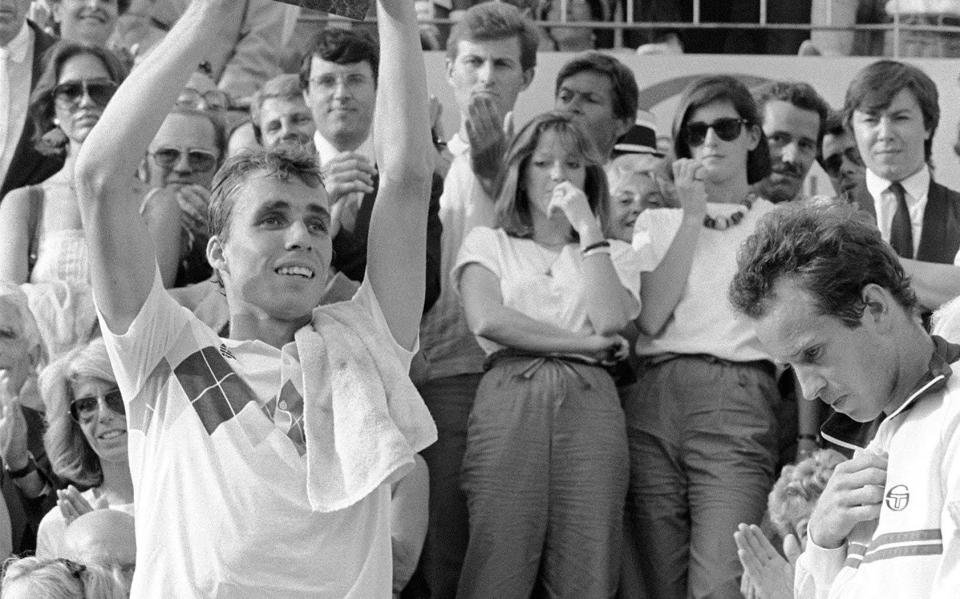 Czech tennis player Ivan Lendl (L) presents the cup he just received for his victory against top-seeded McEnroe in the men's final of the French Tennis Open in Roland Garros in Paris 10 June 1984 as American player looks down. Ivan Lendl won 3-6, 2-6, 6-4, 7-5, 7-5 - GETTY IMAGES