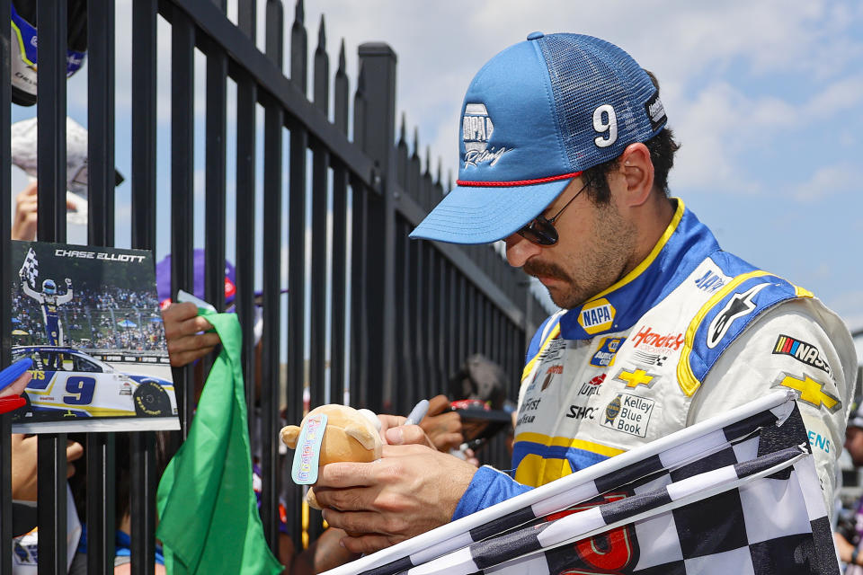 Chase Elliott signs autographs for fans in the garage area prior to the NASCAR Cup Series M&amp;M's Fan Appreciation 400 at Pocono Raceway. (Photo by Tim Nwachukwu/Getty Images)