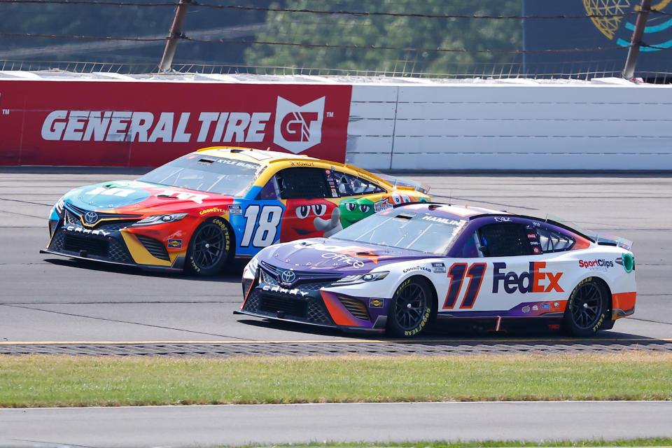 LONG POND, PA - JULY 24: Denny Hamlin (#11 Joe Gibbs Racing FedEx Office Toyota) and Kyle Busch (#18 Joe Gibbs Racing M&amp;M's Toyota) drive during the NASCAR Cup Series M&amp;MS Fan Appreciation 400 on July 24, 2022 at Pocono Raceway in Long Pond, Pennsylvania. (Photo by Rich Graessle/Icon Sportswire via Getty Images)