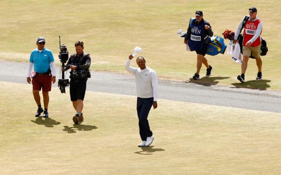 Tiger Woods of the U.S. acknowledges the fans as he walks on the 18th - Reuters