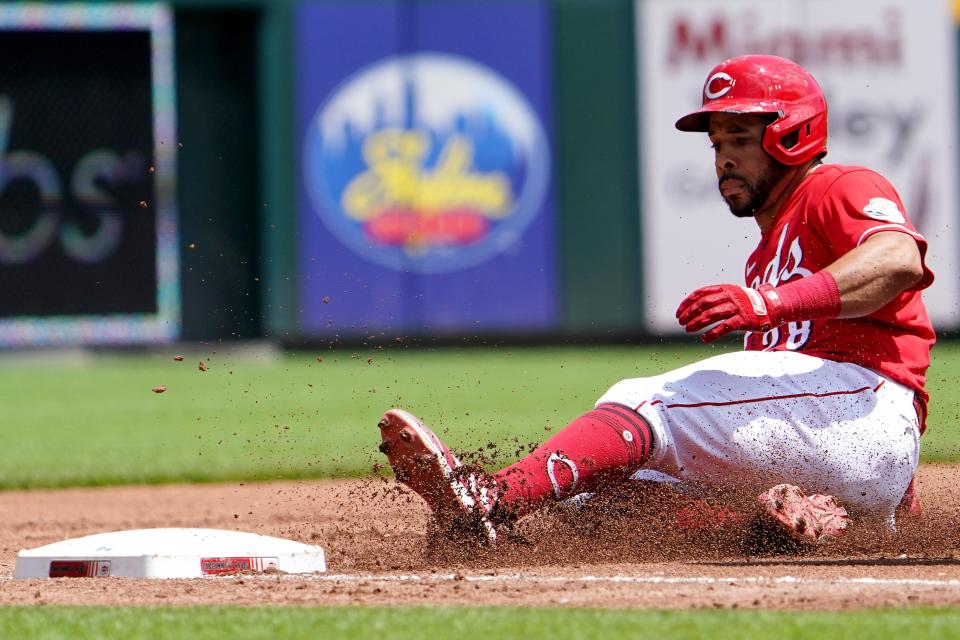 Cincinnati Reds left fielder Tommy Pham (28) slides into third base safely his a triple during the third inning of a baseball game against the Tampa Bay Rays, Sunday, July 10, 2022, at Great American Ball Park in Cincinnati.