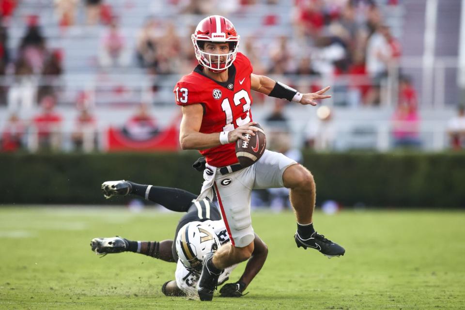 Georgia quarterback Stetson Bennett scrambles away from Vanderbilt linebacker CJ Taylor.