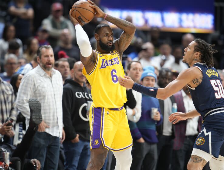 Los Angeles Lakers forward LeBron James, left, looks to pass the ball as Denver Nuggets forward Aaron Gordon.