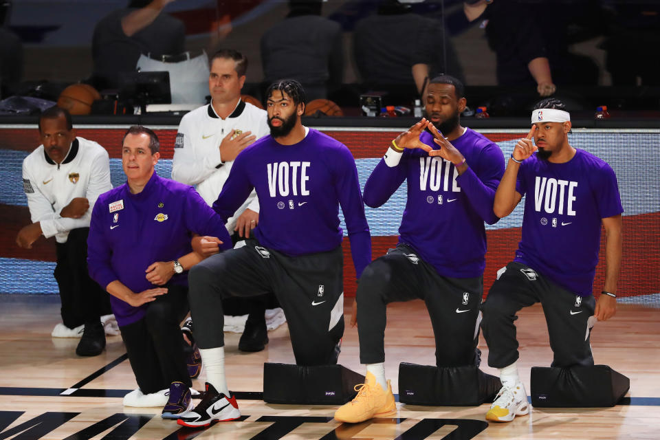 LAKE BUENA VISTA, FLORIDA - OCTOBER 11: LeBron James #23 of the Los Angeles Lakers, Anthony Davis #3 of the Los Angeles Lakers and Frank Vogel of the Los Angeles Lakers kneel during the National Anthem prior to the start of the game aMiami Heat in Game Six of the 2020 NBA Finals at AdventHealth Arena at the ESPN Wide World Of Sports Complex on October 11, 2020 in Lake Buena Vista, Florida. NOTE TO USER: User expressly acknowledges and agrees that, by downloading and or using this photograph, User is consenting to the terms and conditions of the Getty Images License Agreement. (Photo by Mike Ehrmann/Getty Images)