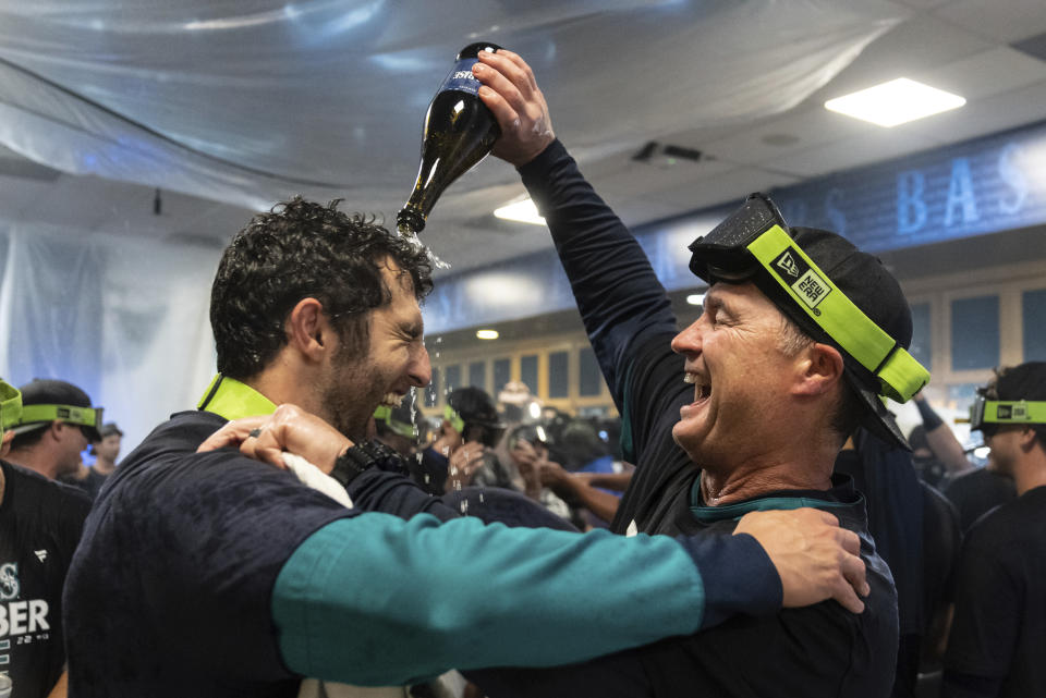 Seattle Mariners manager Scott Servais, right, celebrates in the clubhouse after the team clinched its first playoff berth since 2001 on Friday, Sept. 30, 2022, in Seattle. (AP Photo/Stephen Brashear)