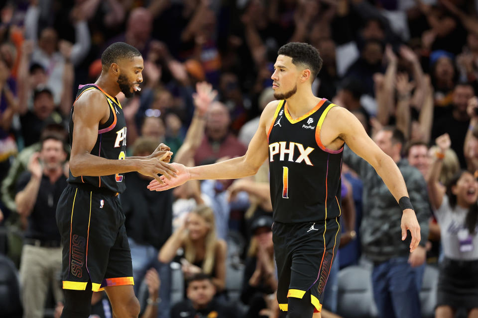 PHOENIX, ARIZONA - OCTOBER 19: Devin Booker #1 of the Phoenix Suns celebrates with Mikal Bridges #25 after defeating the Dallas Mavericks the NBA game at Footprint Center on October 19, 2022 in Phoenix, Arizona. The Suns defeated the Mavericks 107-105. NOTE TO USER: User expressly acknowledges and agrees that, by downloading and or using this photograph, User is consenting to the terms and conditions of the Getty Images License Agreement. (Photo by Christian Petersen/Getty Images)