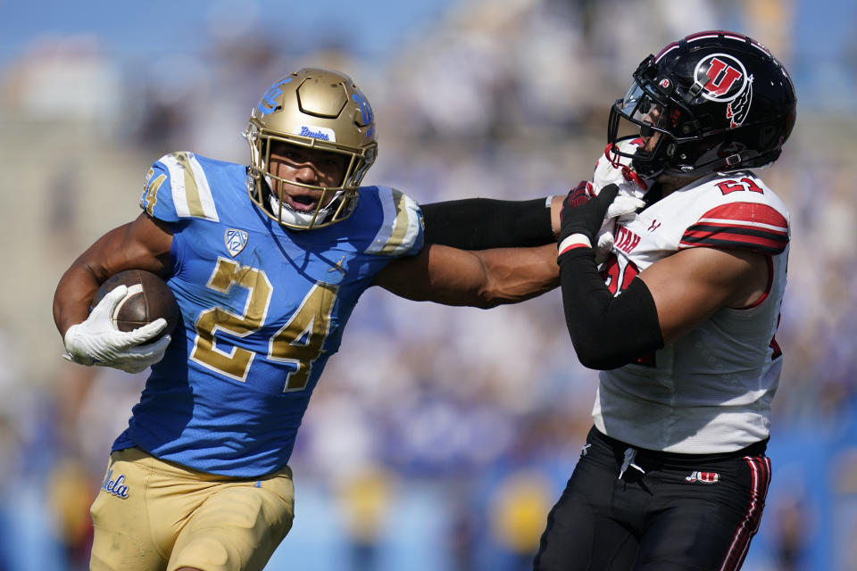 UCLA running back Zach Charbonnet (24) stiff arms Utah linebacker Karene Reid (21) during the game in Pasadena, Calif., Saturday, Oct. 8, 2022. (AP Photo/Ashley Landis)