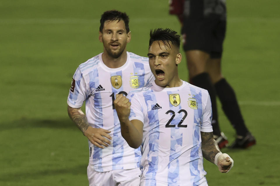 Argentina's Lautaro Martinez, right, celebrates scoring the opening goal against Venezuela beside teammate Lionel Messi during a qualifying soccer match for the FIFA World Cup Qatar 2022 in Caracas, Venezuela, Thursday, Sept. 2, 2021. (Miguel Gutierrez, Pool via AP)