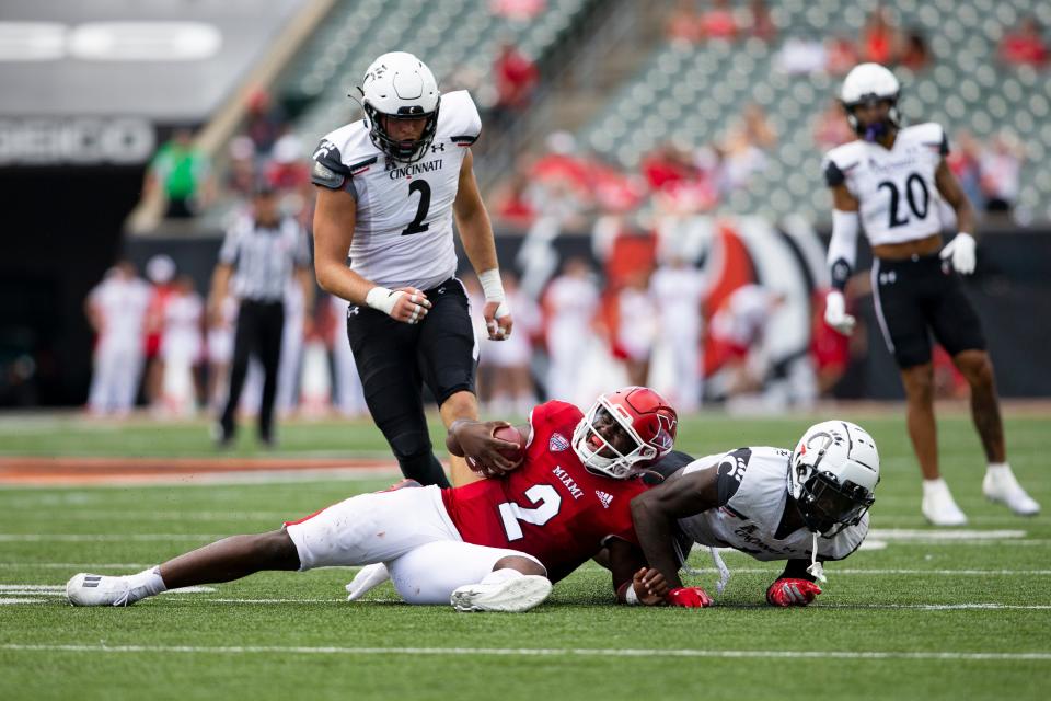 Cincinnati Bearcats defensive back JQ Hardaway tackles Miami (Ohio) quarterback Aveon Smith.