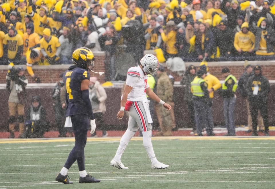 Ohio State Buckeyes quarterback C.J. Stroud (7) walks off the field behind Michigan Wolverines defensive back Vincent Gray (4) during the fourth quarter of the NCAA football game at Michigan Stadium in Ann Arbor on Saturday, Nov. 27, 2021. Ohio State lost 42-27.