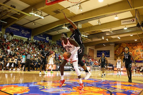 Oumar Ballo of the Arizona Wildcats is fouled by Kalu Ezikpe of the Cincinnati Bearcats.