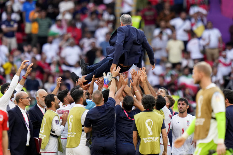 Players throw Iran's head coach Carlos Queiroz in air as they celebrate after their win in the World Cup group B soccer match between Wales and Iran, at the Ahmad Bin Ali Stadium in Al Rayyan, Qatar, Friday, Nov. 25, 2022. (AP Photo/Alessandra Tarantino)