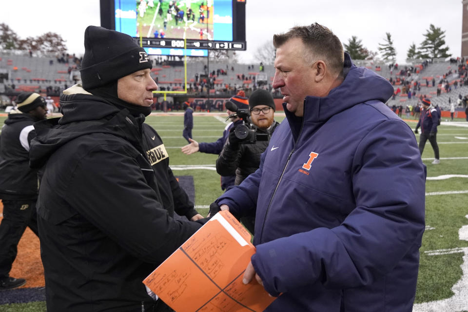Purdue head coach Jeff Brohm, left, and Illinois head coach Bret Bielema meet after Purdue's 31-24 win over Illinois after an NCAA college football game Saturday, Nov. 12, 2022, in Champaign, Ill. (AP Photo/Charles Rex Arbogast)