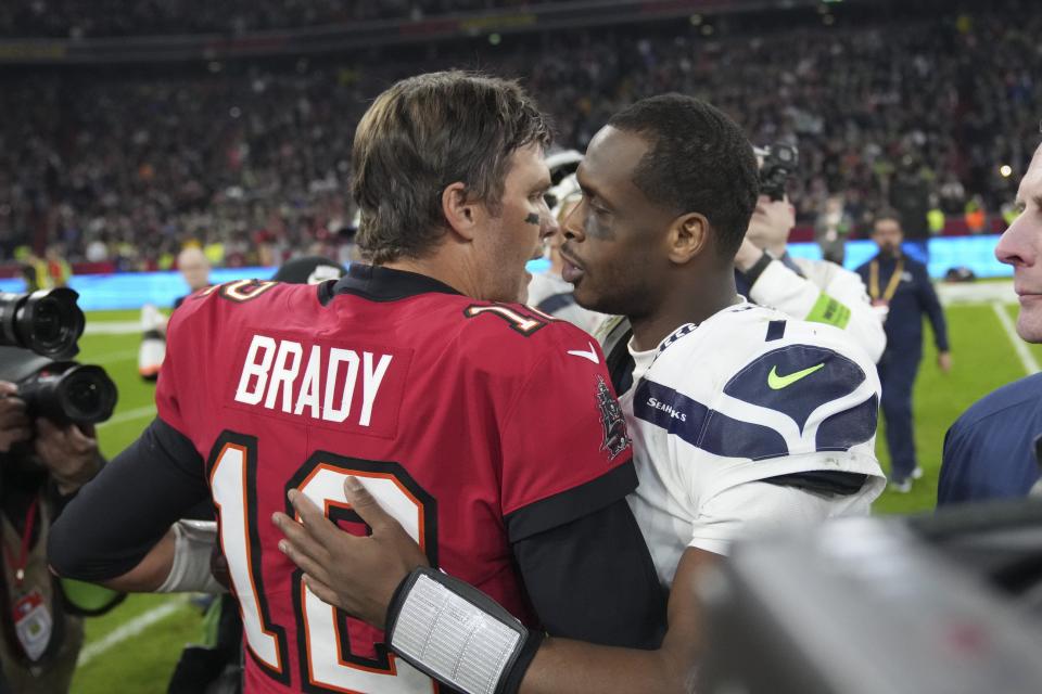 Tampa Bay Buccaneers quarterback Tom Brady (12) talks with Seattle Seahawks quarterback Geno Smith (7) following of an NFL football game, Saturday, Nov. 13, 2021, in Munich, Germany. (AP Photo/Matthias Schrader)