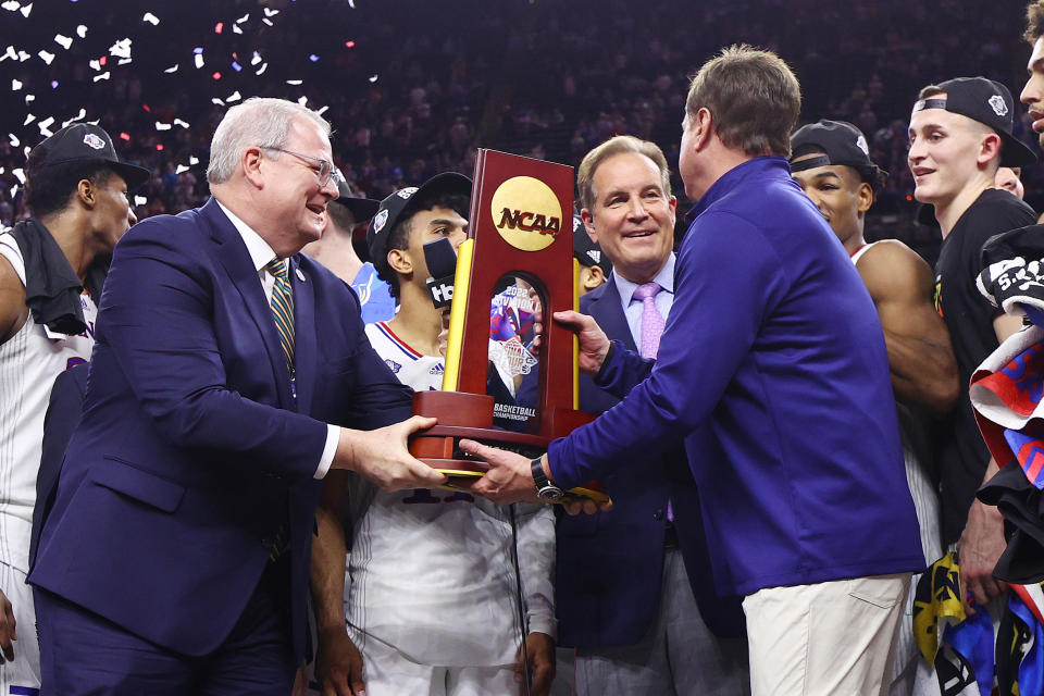 Jim Nantz presents the NCAA national championship trophy to Kansas head coach Bill Self after his team defeated the North Carolina Tar Heels to win the 2022 title. (Jamie Schwaberow/NCAA Photos via Getty Images)